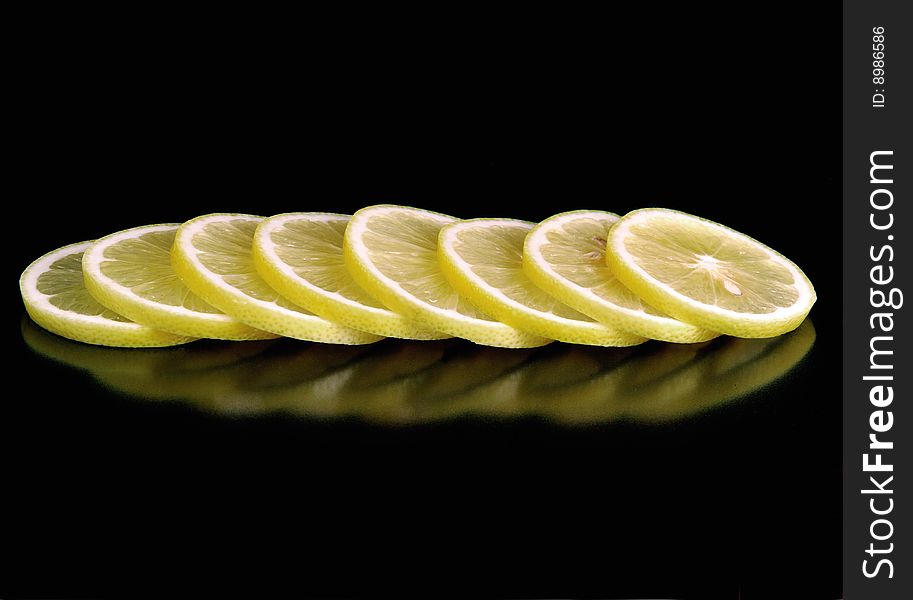 A sliced of lemon on black background. A sliced of lemon on black background