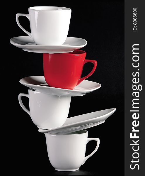 White cups and saucers on black background