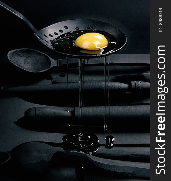 Egg on black background and black spoon. Egg on black background and black spoon