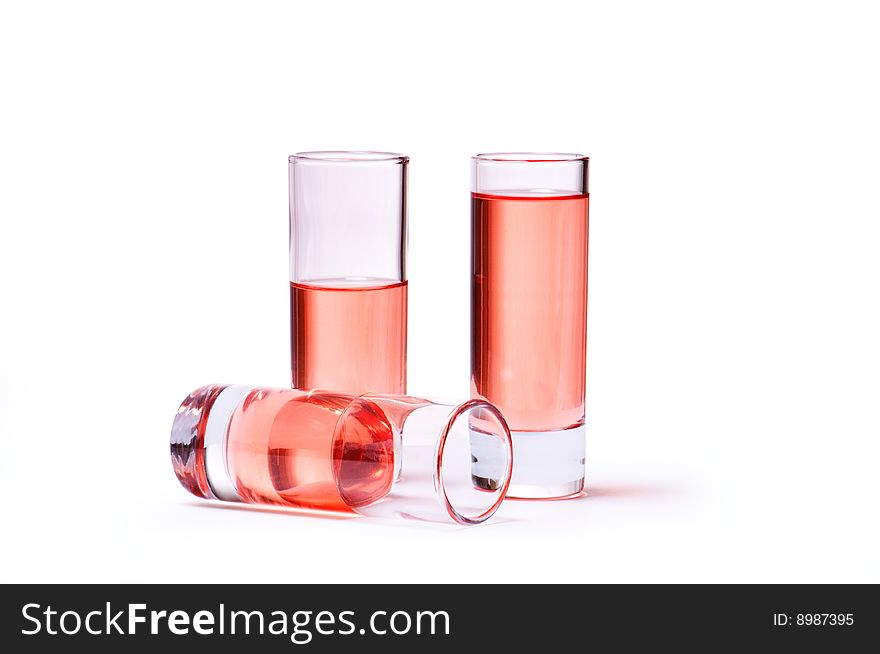 Thin glasses with pink liquid on white background