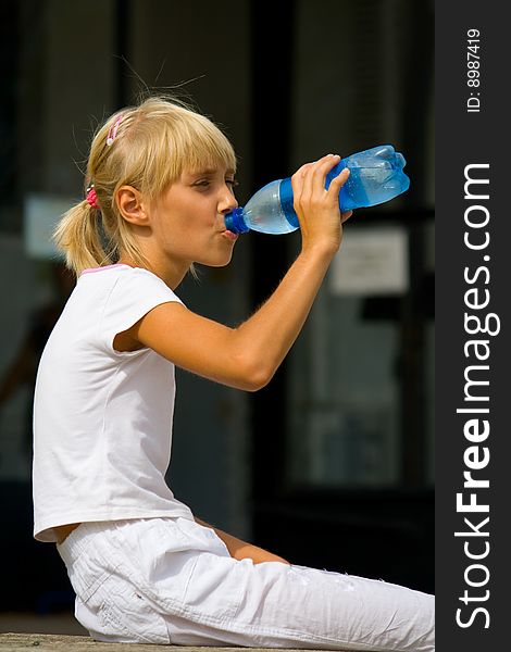 A young girl drinking water from a bottle. A young girl drinking water from a bottle