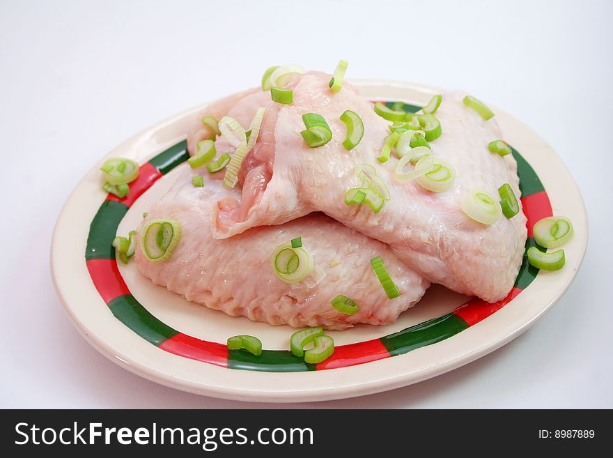 Fresh, raw chicken wings with spring onions. Fresh, raw chicken wings with spring onions