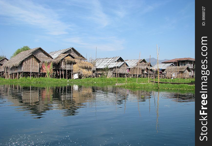 Lakeside village under bright blue sky. Myanmar, Burma.