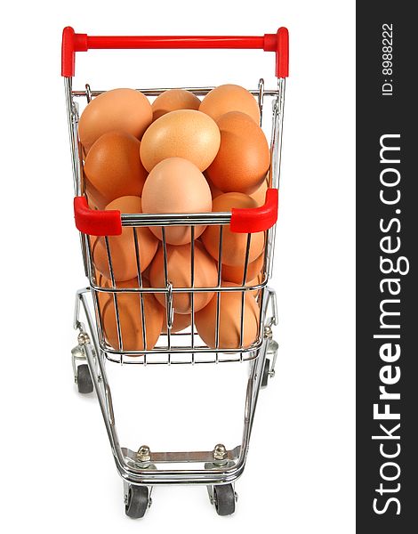 Shopping trolley filled with brown eggs on bright background