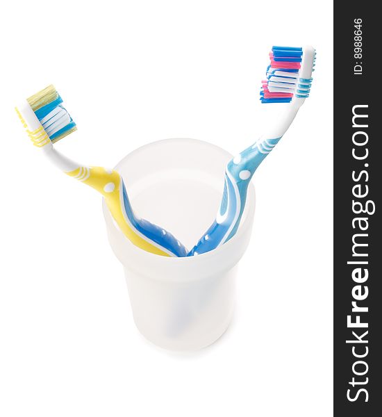 Tooth brush in a glass on a white background