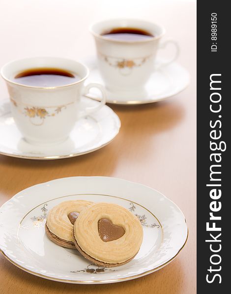 Coffee and heart shaped cookie on table