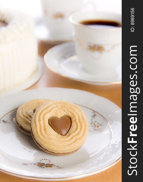 Coffee and heart shaped cookie on table