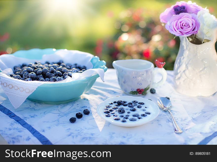 Bowl Of Blue Berries On A Table In A Garden On A Sunny Day