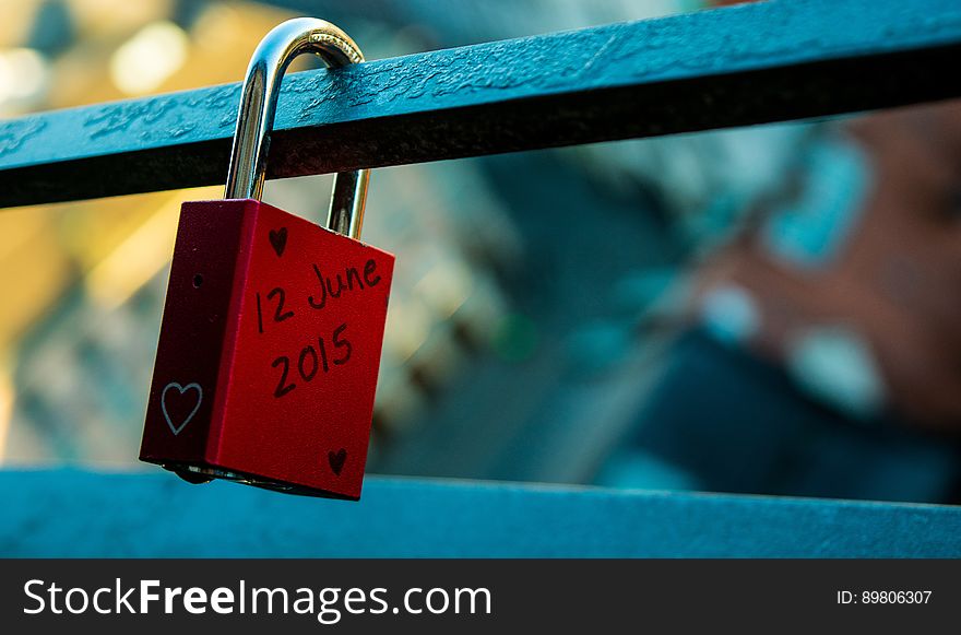 A single red love lock on a balcony.
