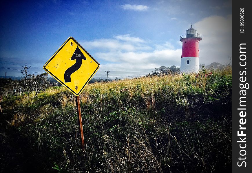 A lighthouse and a warning sign on the coast.