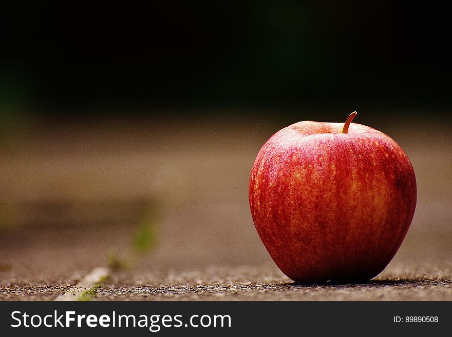 A close up of a red apple on table.