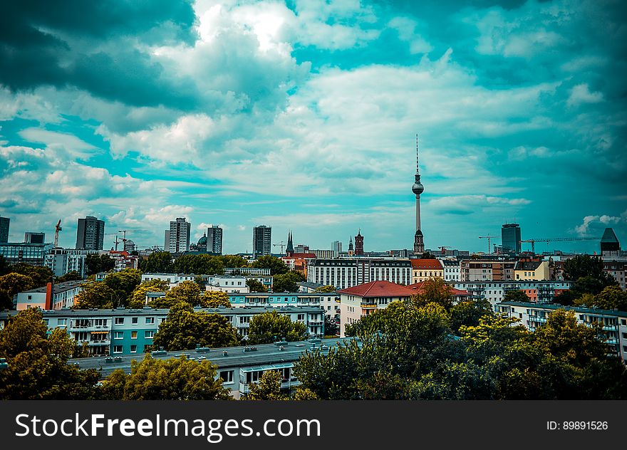 Urban skyline over rooftops with modern skyscrapers and tower against blue skies. Urban skyline over rooftops with modern skyscrapers and tower against blue skies.