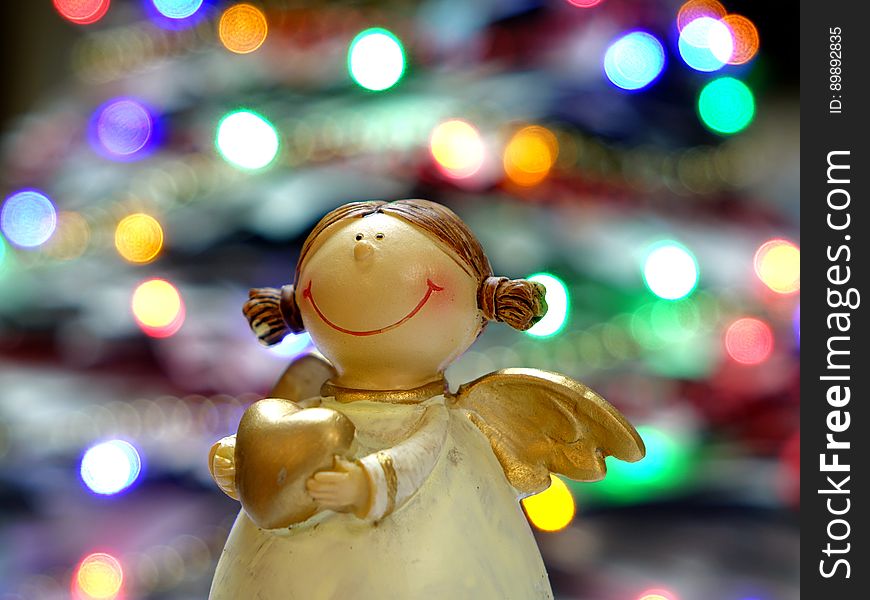 Bokeh Shot Of White And Gold Ceramic Angel