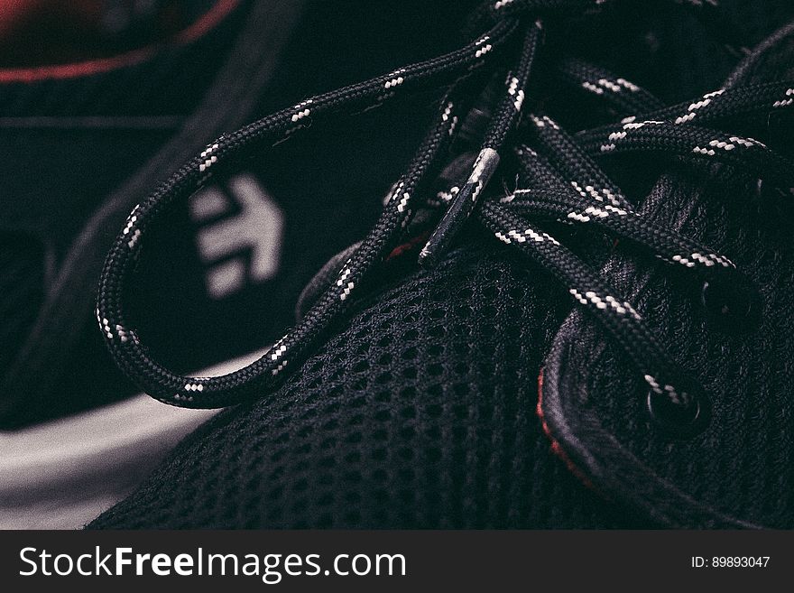 A close up of black and white laces on a sneaker. A close up of black and white laces on a sneaker.