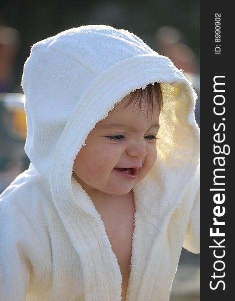 Laughing child in white bathrobe happy about something. Laughing child in white bathrobe happy about something