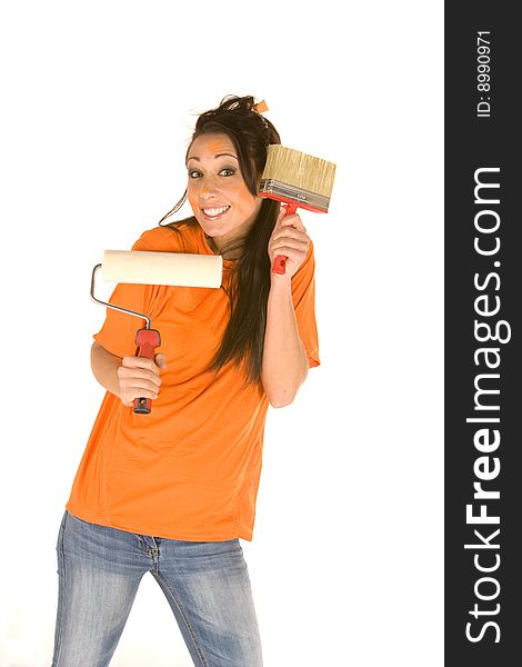 Young caucasian brunette holding a brush with orange t-shirt and orange paint on her face,making facial expression. Young caucasian brunette holding a brush with orange t-shirt and orange paint on her face,making facial expression