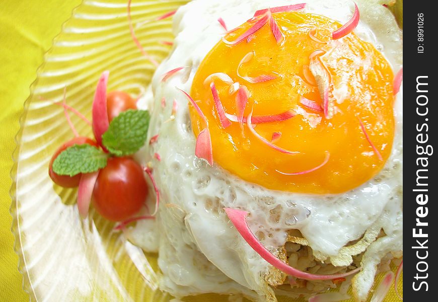 Fried rice top put with fried egg with cherry tomato and some ginger flower. Fried rice top put with fried egg with cherry tomato and some ginger flower