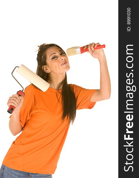 Young caucasian brunette holding a brush with orange t-shirt and orange paint on her face,making facial expression. Young caucasian brunette holding a brush with orange t-shirt and orange paint on her face,making facial expression