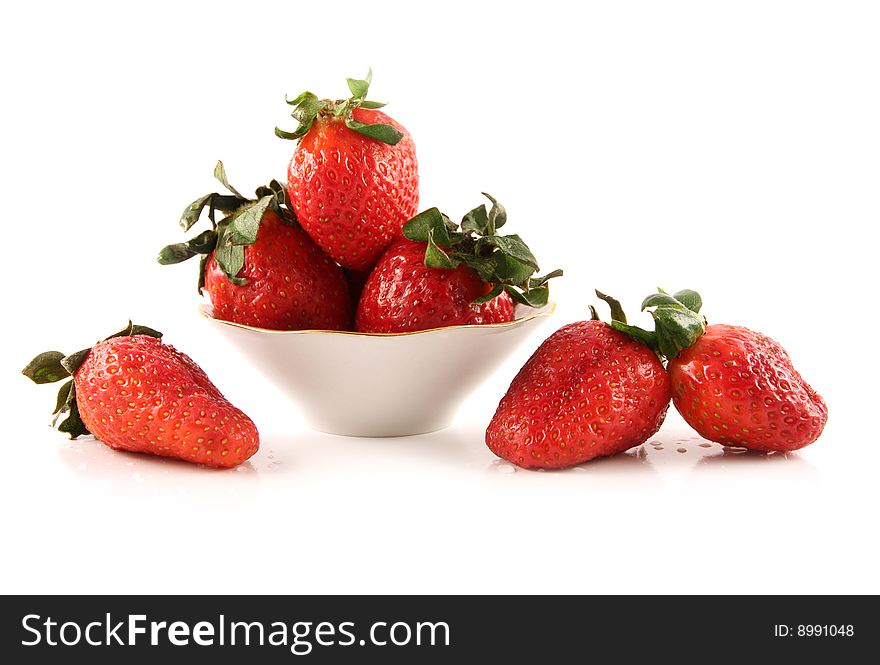 The fresh strawberry lies on a white surface and in a saucer. The fresh strawberry lies on a white surface and in a saucer