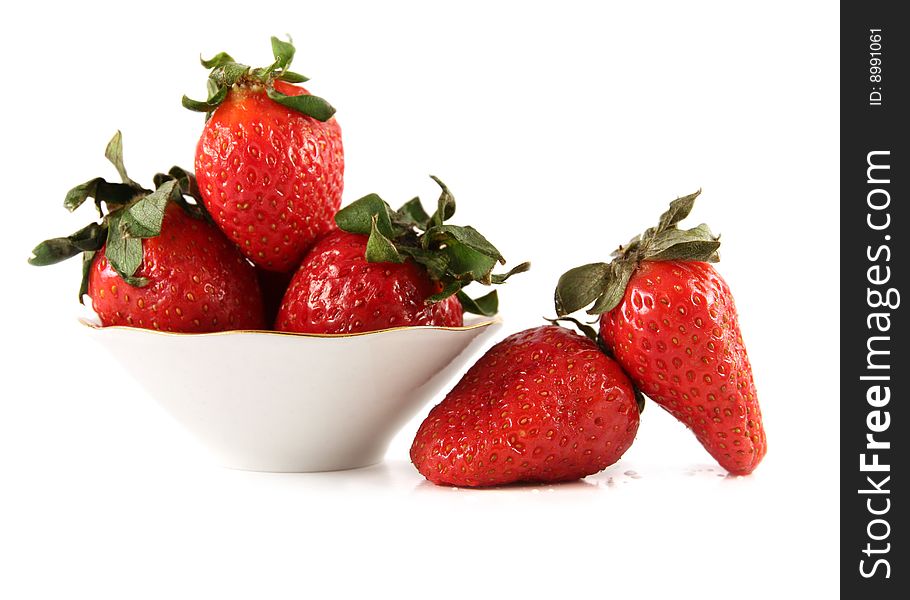 The fresh strawberry lies on a white surface and in a saucer. The fresh strawberry lies on a white surface and in a saucer