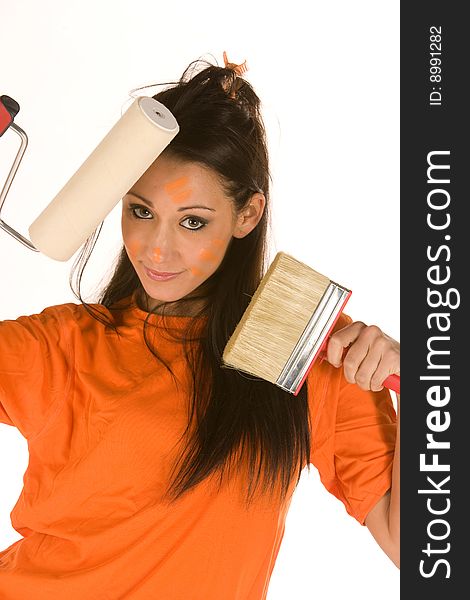 Young caucasian brunette holding a brush with orange t-shirt and orange paint on her face,making facial expression. Young caucasian brunette holding a brush with orange t-shirt and orange paint on her face,making facial expression