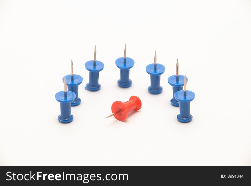 Blue push-pins isolated on white background with a red one fallen. Blue push-pins isolated on white background with a red one fallen