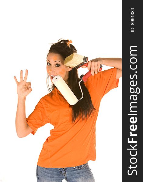 Young caucasian brunette holding a brush with orange t-shirt and orange paint on her face,making facial expression. Young caucasian brunette holding a brush with orange t-shirt and orange paint on her face,making facial expression