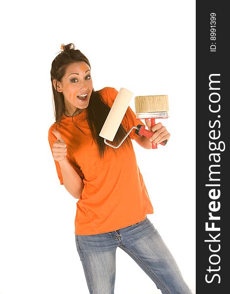 Young caucasian brunette holding a brush with orange t-shirt and orange paint on her face,making facial expression. Young caucasian brunette holding a brush with orange t-shirt and orange paint on her face,making facial expression