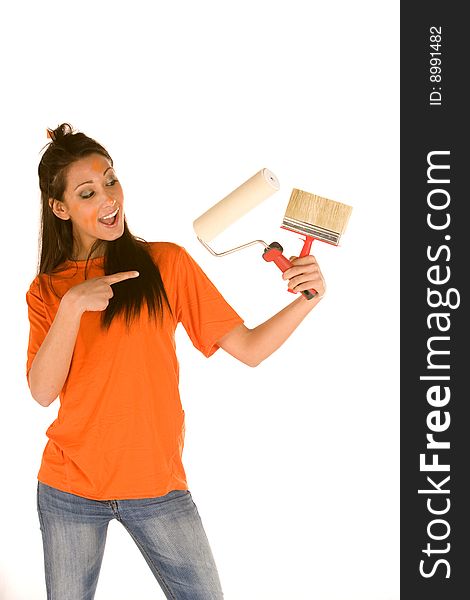 Young caucasian brunette holding a brush with orange t-shirt and orange paint on her face,making facial expression. Young caucasian brunette holding a brush with orange t-shirt and orange paint on her face,making facial expression