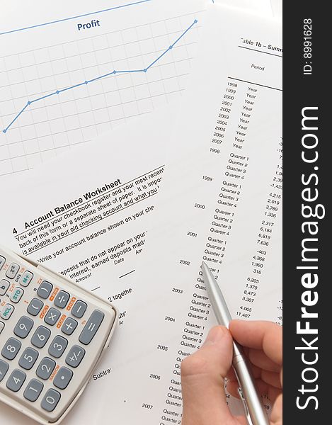 Businessman analyzing financial figures on account balance worksheet using scientific calculator