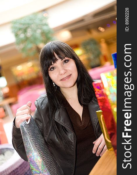 Happy brunette woman in shopping mall. Happy brunette woman in shopping mall