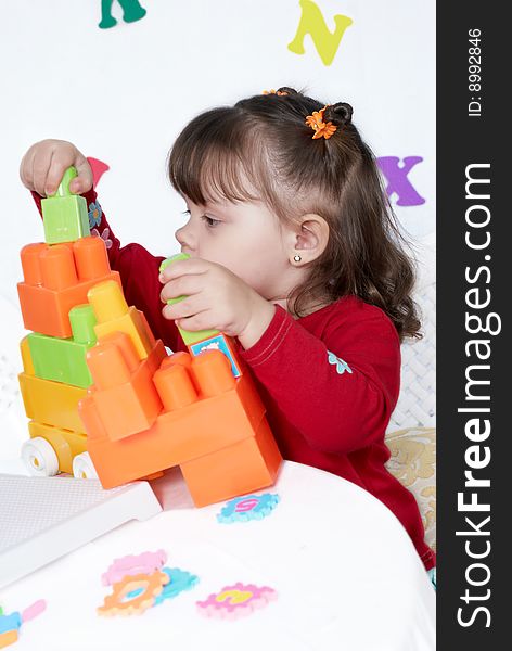 Little Girl Plays A Colorful Cubes