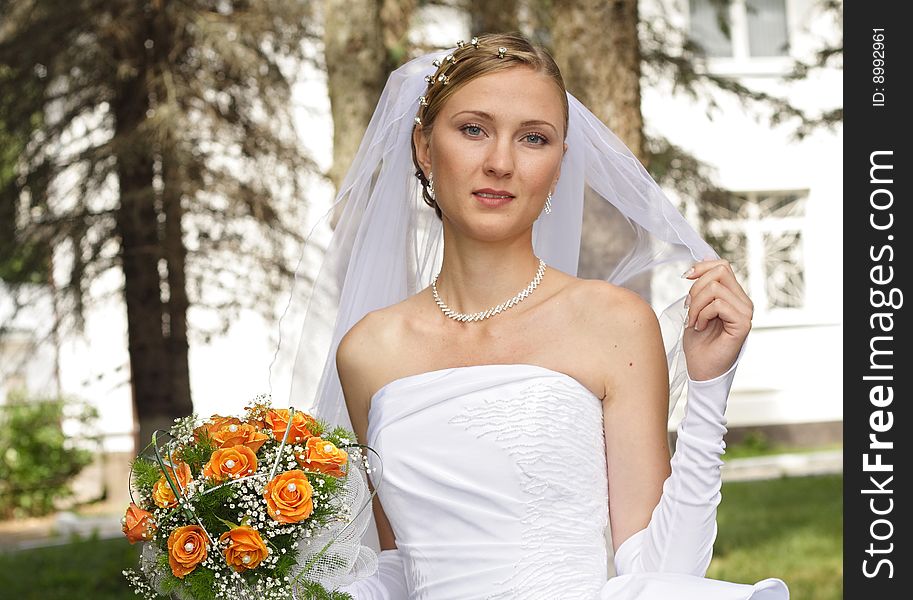 Beautiful bride with bouquet in sunny day