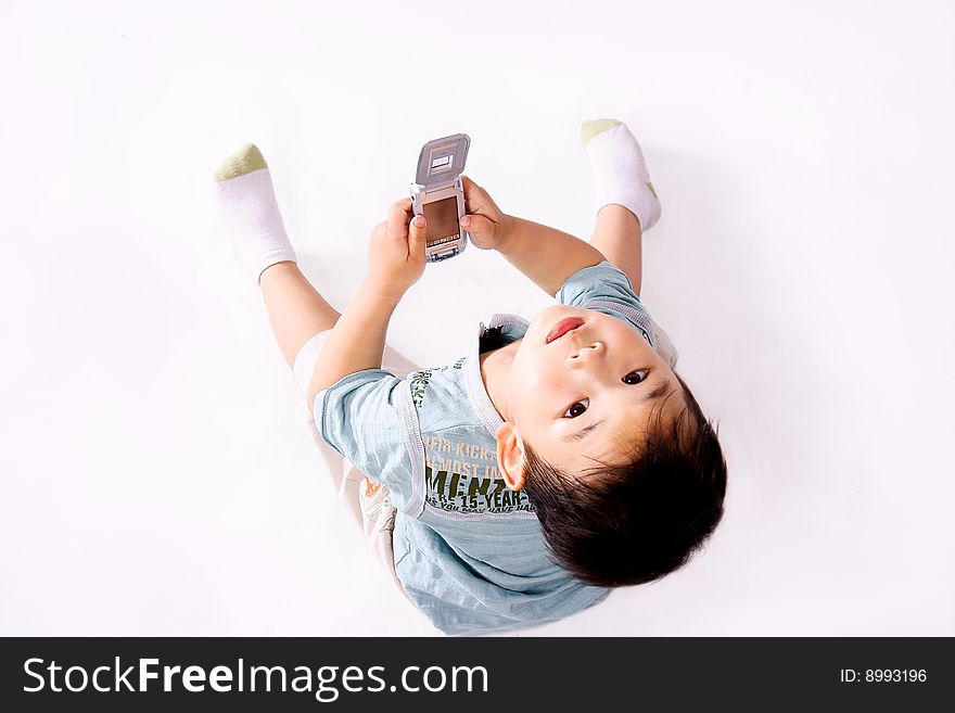 A picture of a little chinese boy looking upward with cell phone in hand
