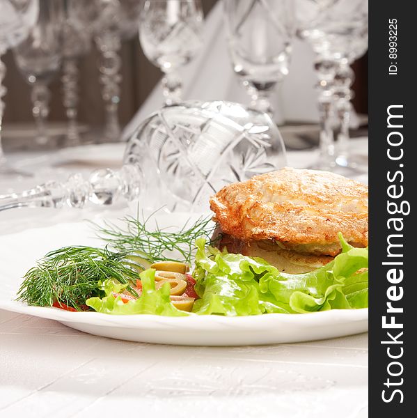 Tasty backed meat and green salad with goblets