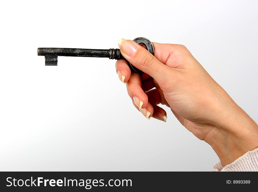 Hand with a key on a grey background. Hand with a key on a grey background