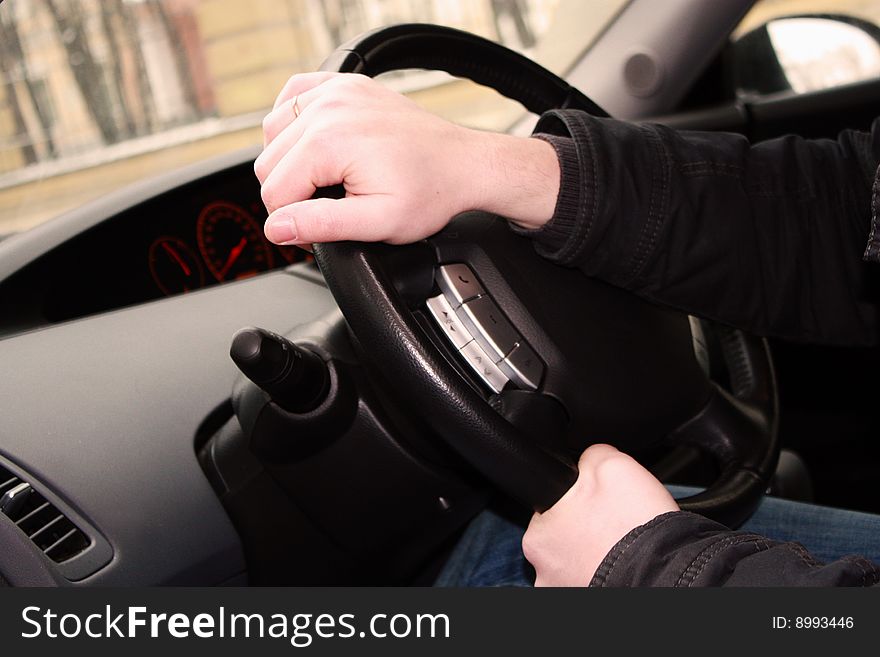 Men's hands holding the steering wheel. Men's hands holding the steering wheel