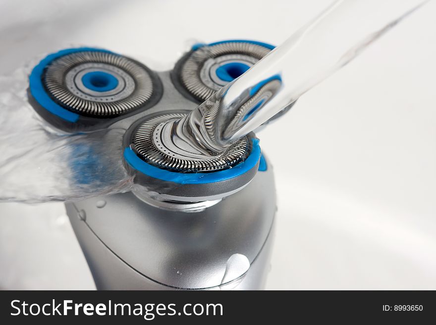 Electric Rotary Three Headed Shaver being rinsed under the tap, New floating head design. Electric Rotary Three Headed Shaver being rinsed under the tap, New floating head design