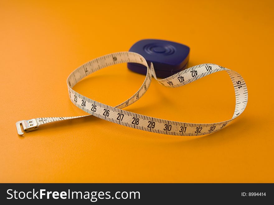 Tape measure isolated on a orange background