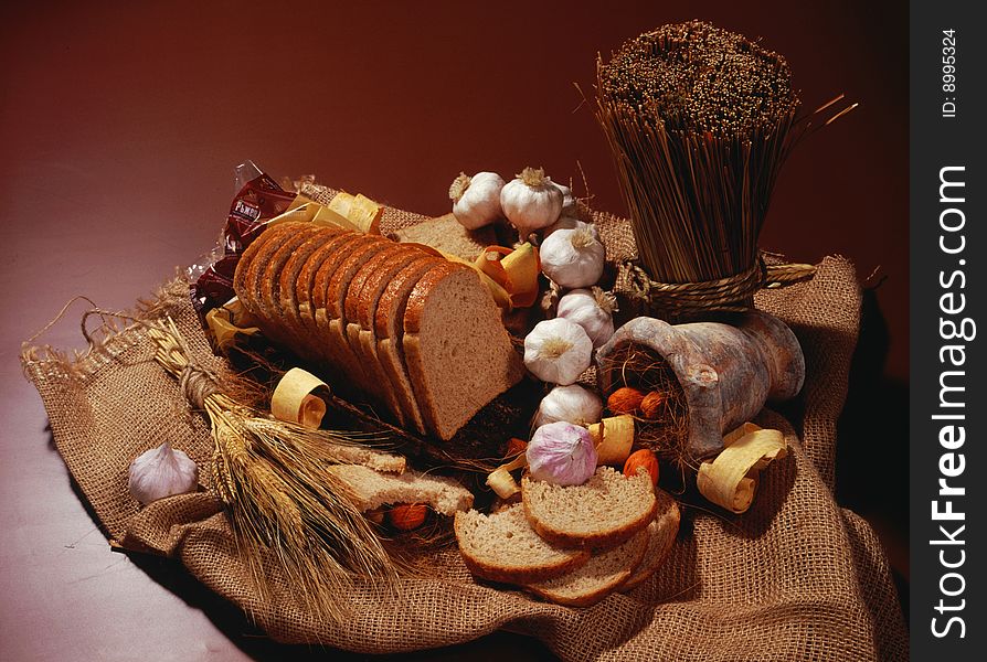 Ryebread and wheat on brown background