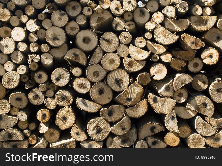 Pile of coniferous tree fire-wood close-up background. Pile of coniferous tree fire-wood close-up background