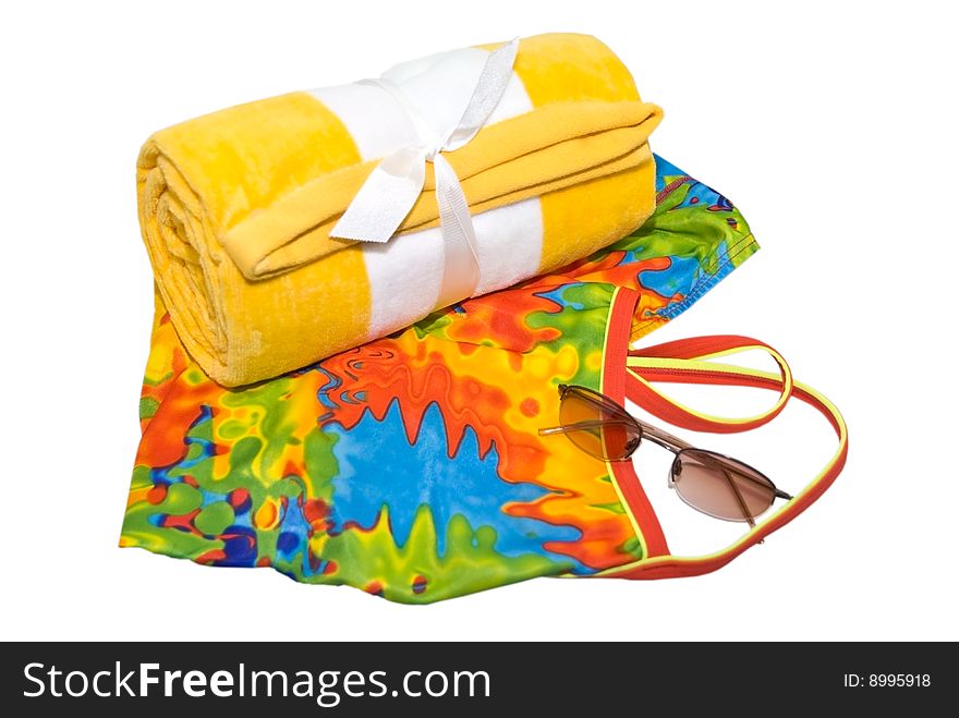 A colorful swimsuit, towel and a pair of sunglasses ready for a day at the beach or pool. A colorful swimsuit, towel and a pair of sunglasses ready for a day at the beach or pool.