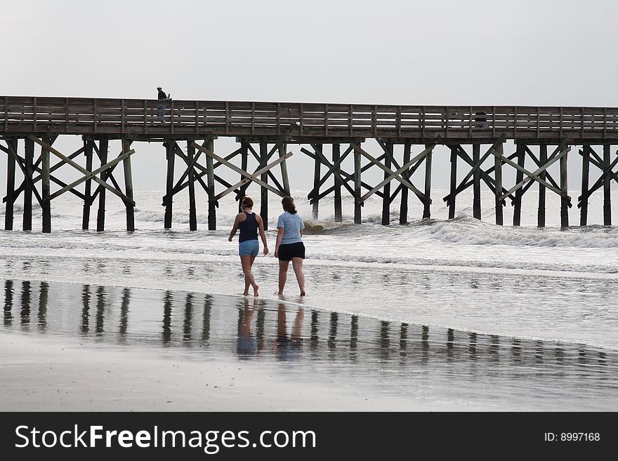 Walking on beach with pier