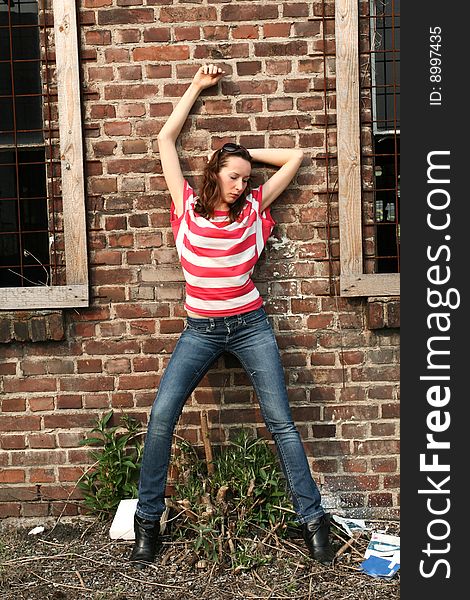 Fashion woman posing at the brick wall. Fashion woman posing at the brick wall