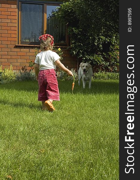 Garden. little girl with best friend and carrot