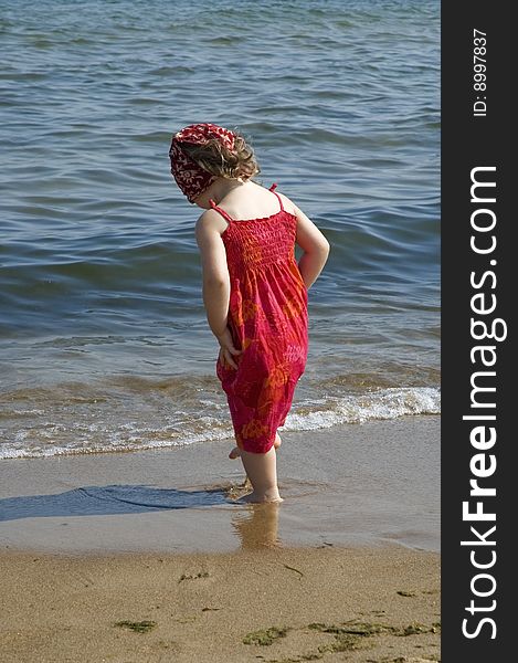 Little girl in red dress on the beach. Little girl in red dress on the beach