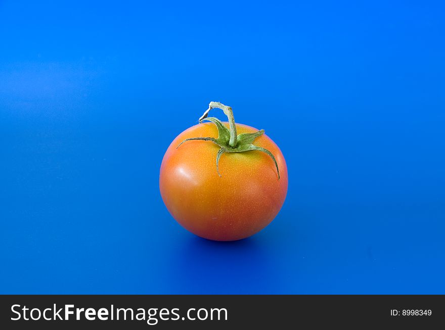 Close up of red ripe tomatoe against the blue background