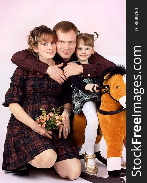 Portrait of a young family. The daddy, mum and a daughter wait for the second child. New images every week