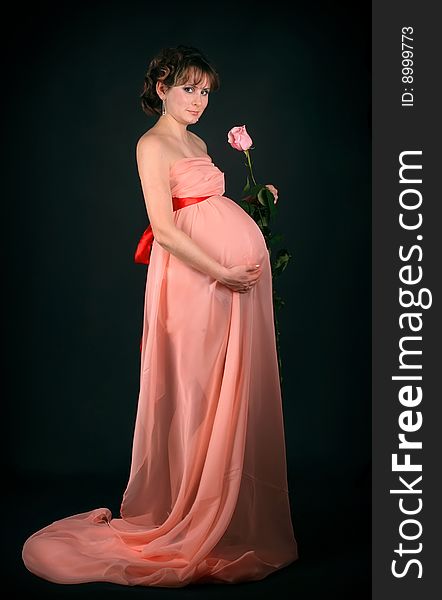 Pregnant woman on dark background. New photos every week