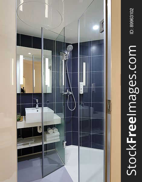 A modern bathroom with glass shower enclosure.